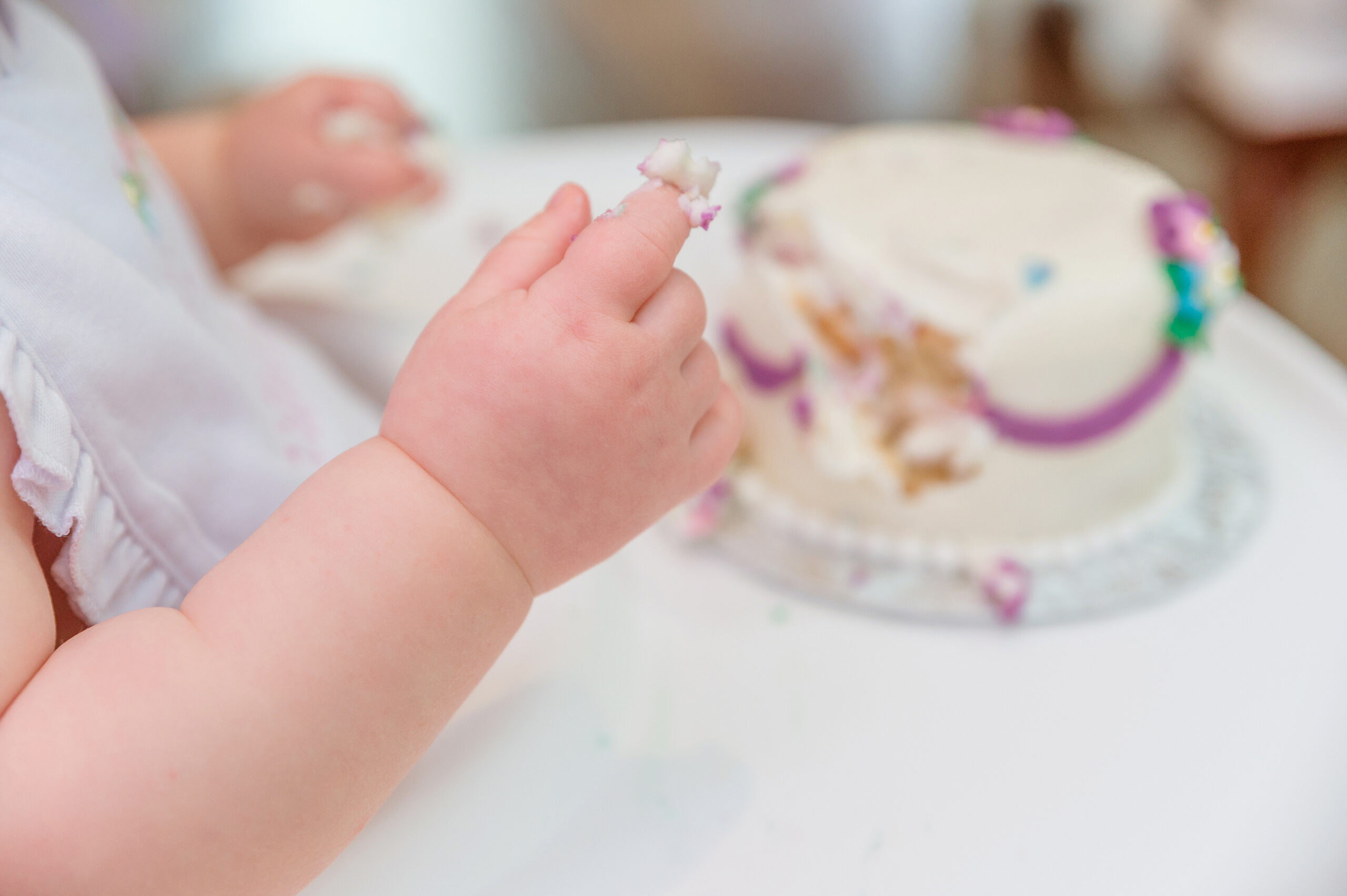 Baby hand covered in cake.