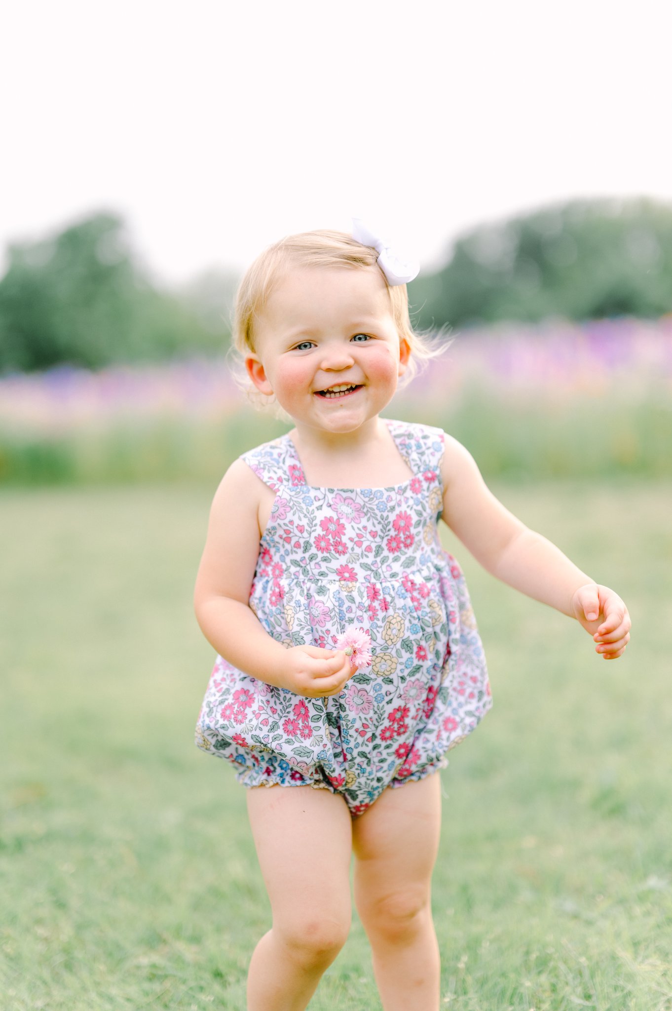 Toddler running in front of a flower field.