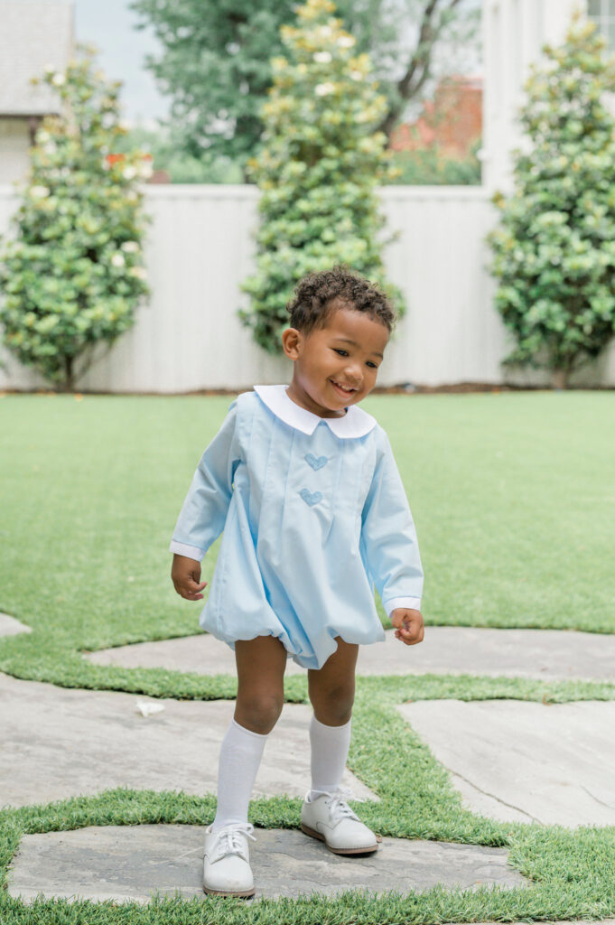 Toddler wearing romper and classic children's shoes.